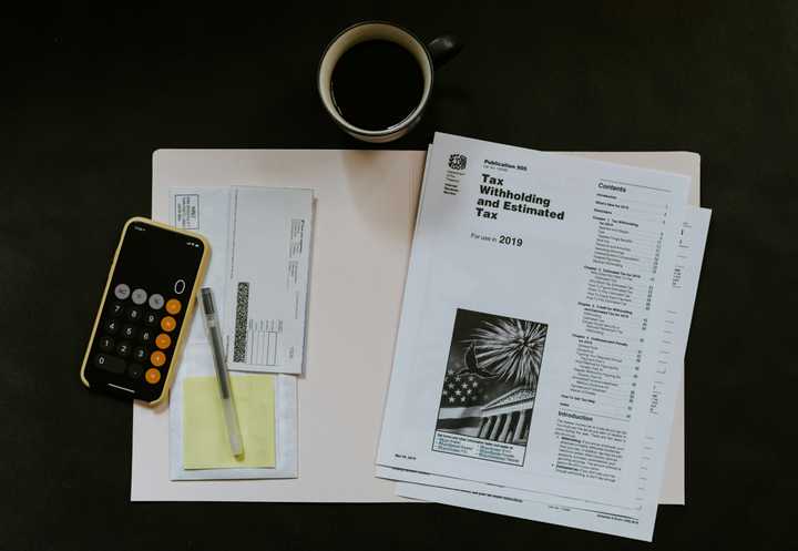 Deklarationspapper, miniräknare och kaffekopp