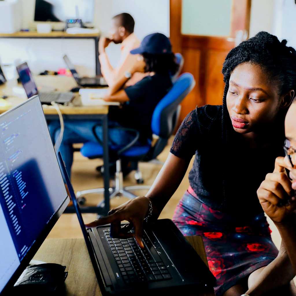 Colleagues are gathered around a computer to check the screen