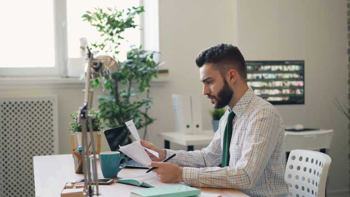 A person checking documents by the desk