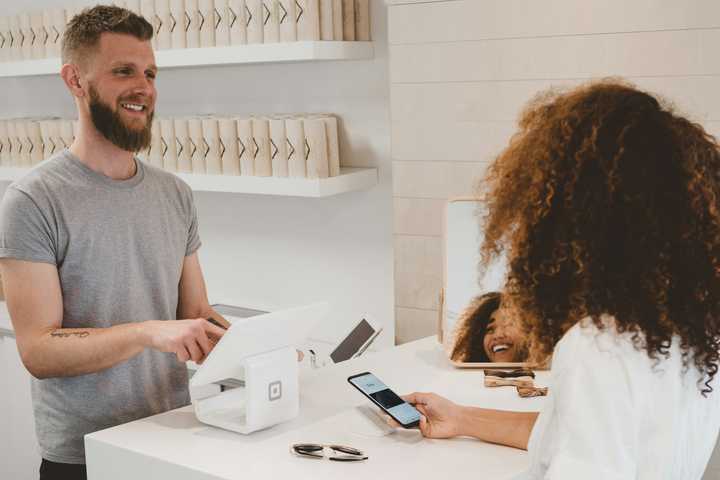 A shopowner receiving a payment from the cashier