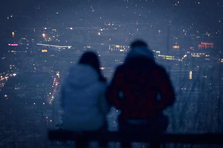 Pariskunta katsoo pimenevää kaupunkia