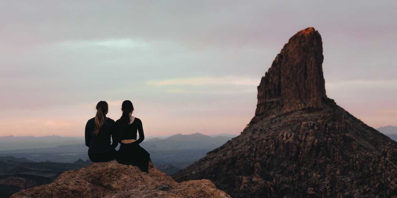 2 ihmistä istumassa vuorella