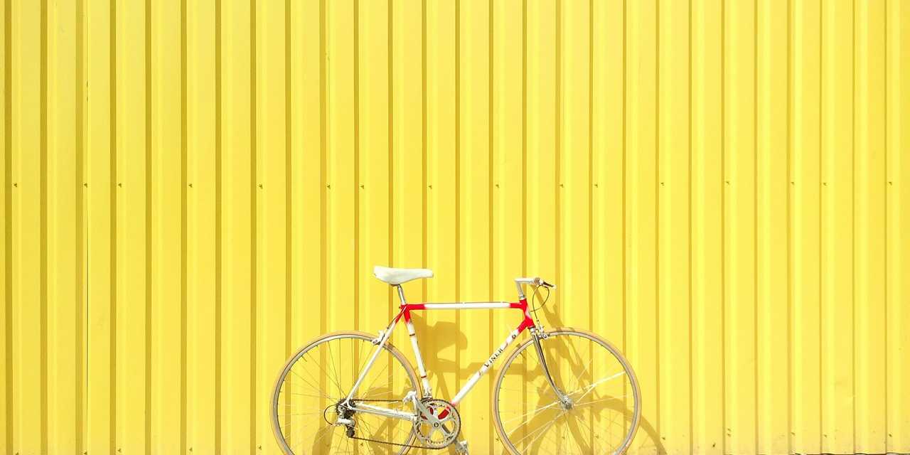 Polkupyörä vasten keltaista seinää. 