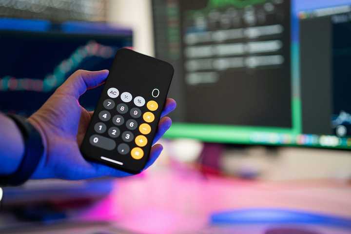 En person håller upp en telefon med kalkylatorn som visar 0