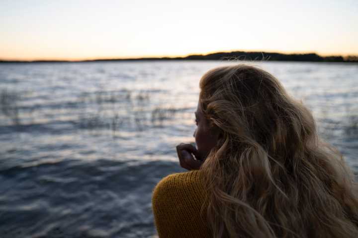 Nainen katsoo järvelle
