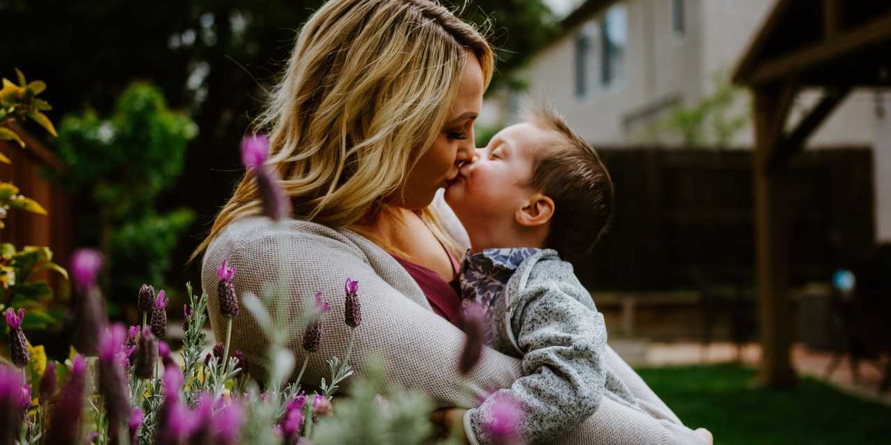 Mamma som omfamnar sin yngre son