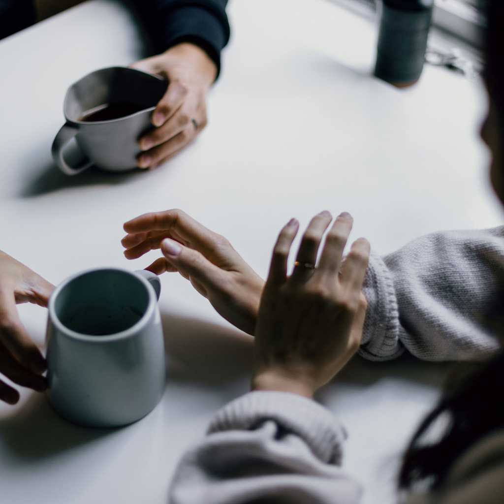 Two people talking over a cup of coffee