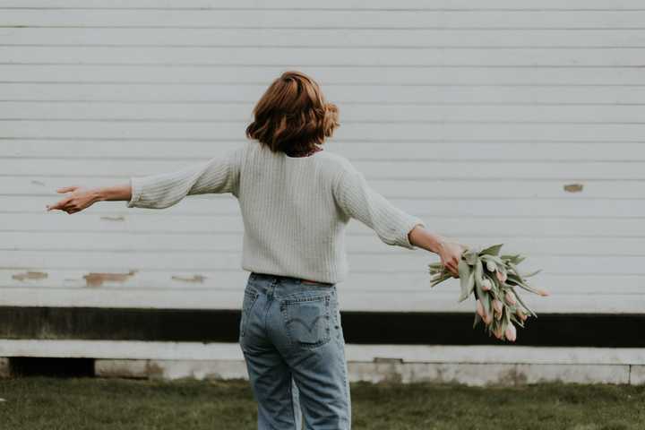 Nainen tanssii tulppaanikimpun kanssa