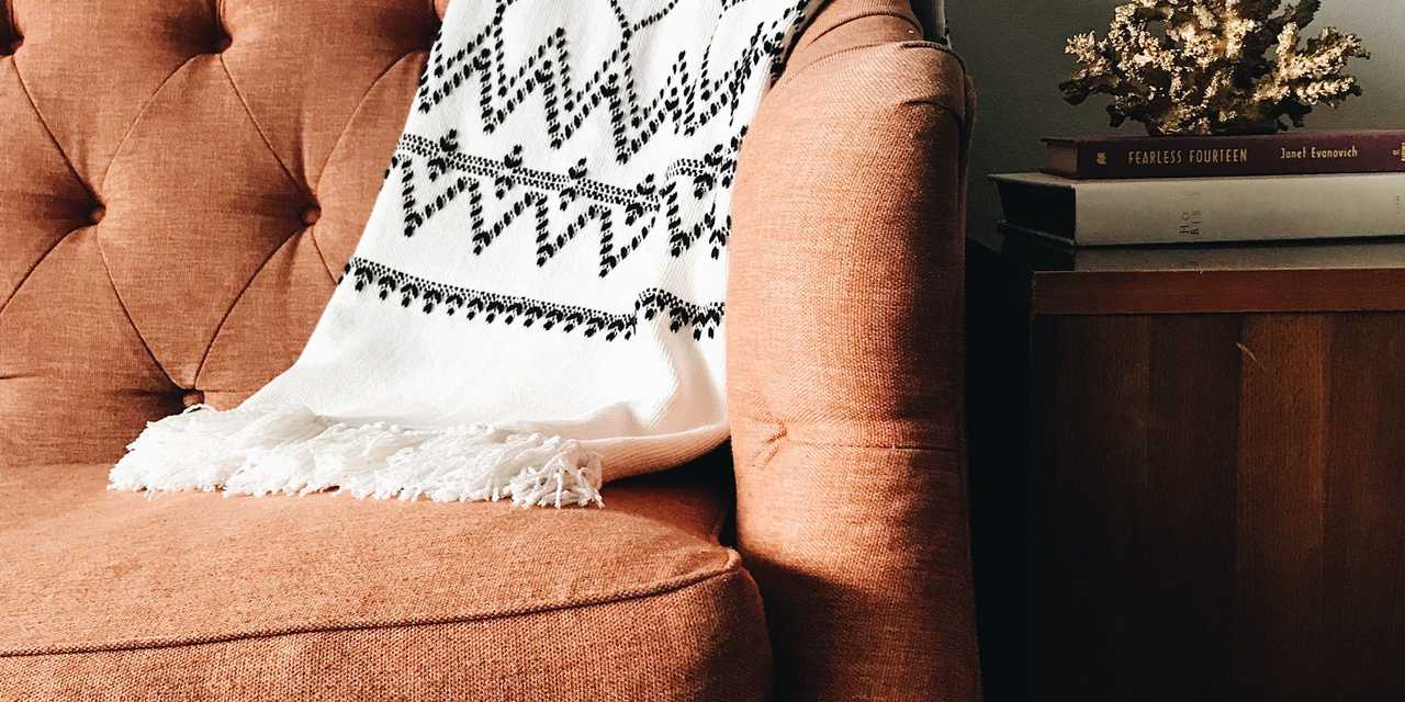sohva, lipasto ja valkoinen seinä