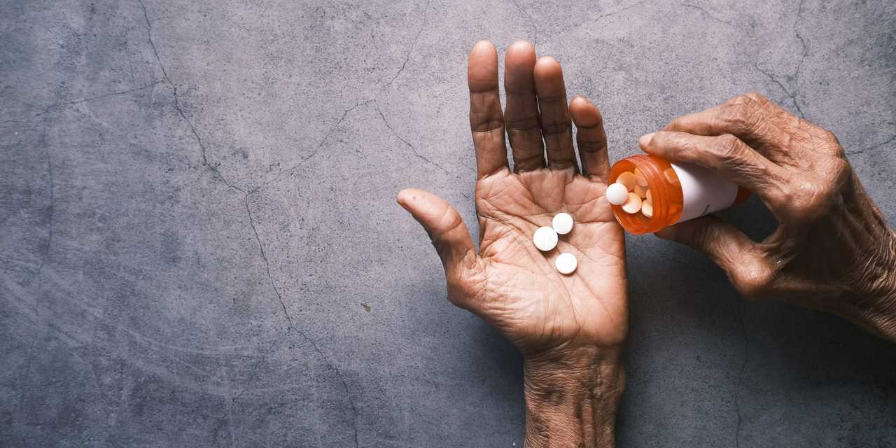 Händer som håller i en medicinburk