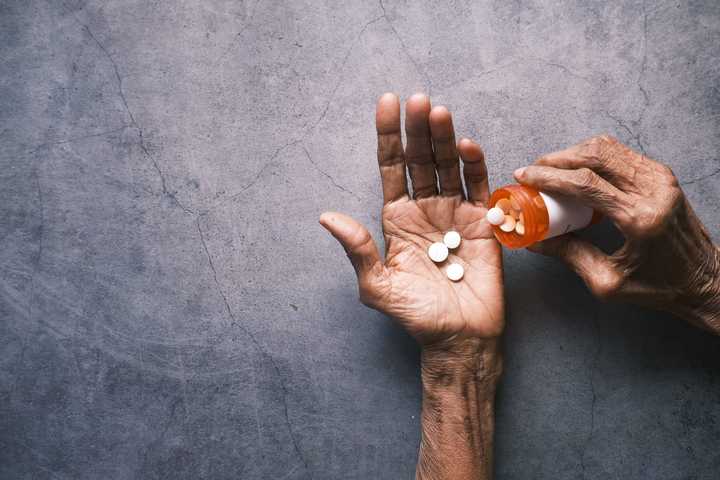 Händer som håller i en medicinburk