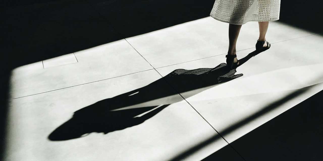 A person walking forward and leaving a shadow behind.