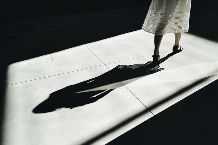 A person walking forward and leaving a shadow behind.