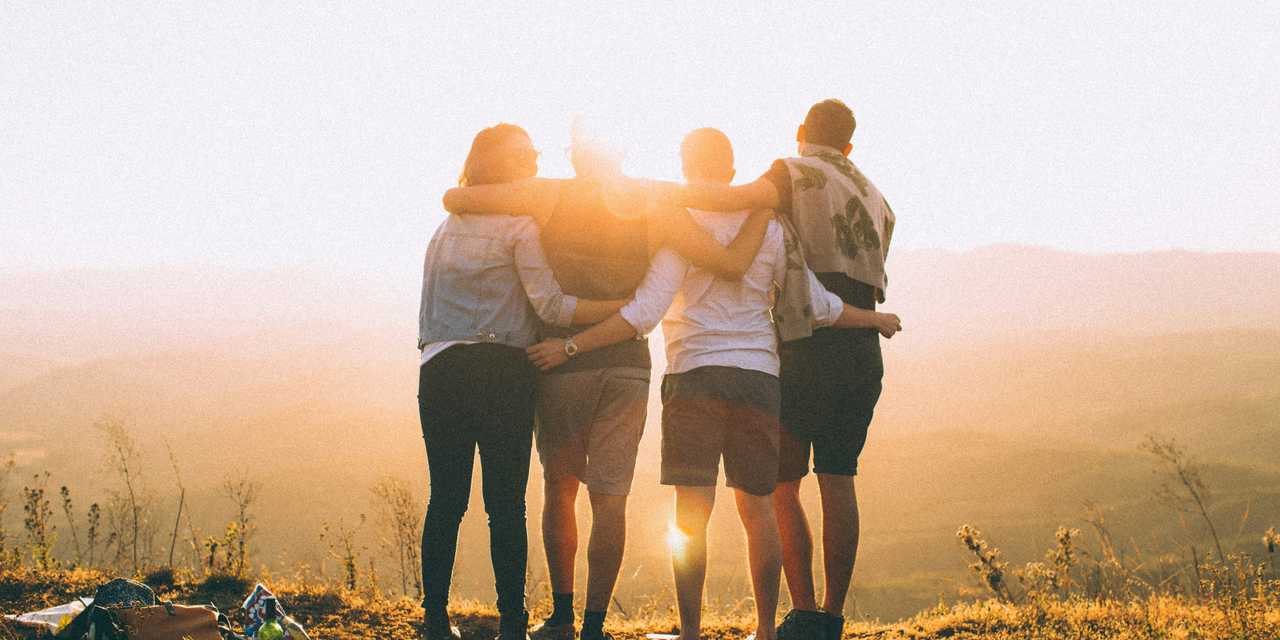 A family hugging on top of a hill