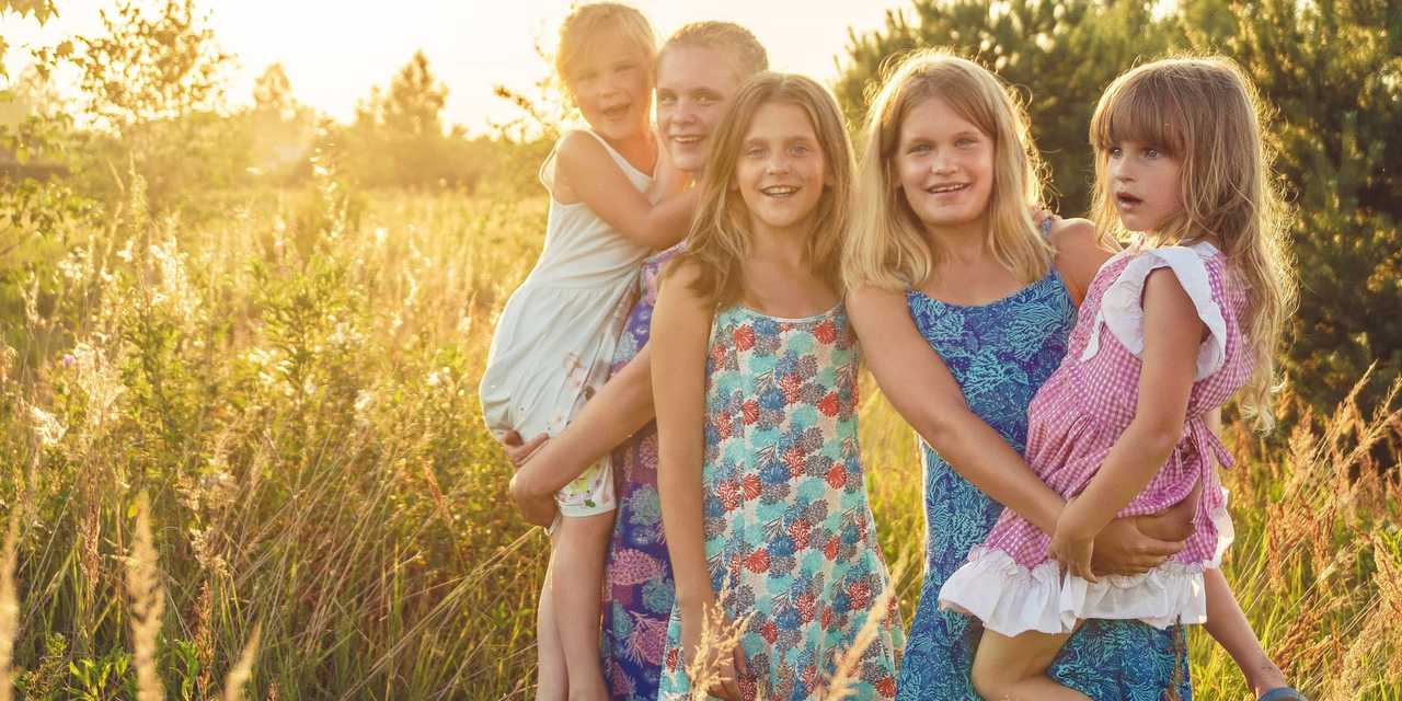 Familj med tre barn på en äng