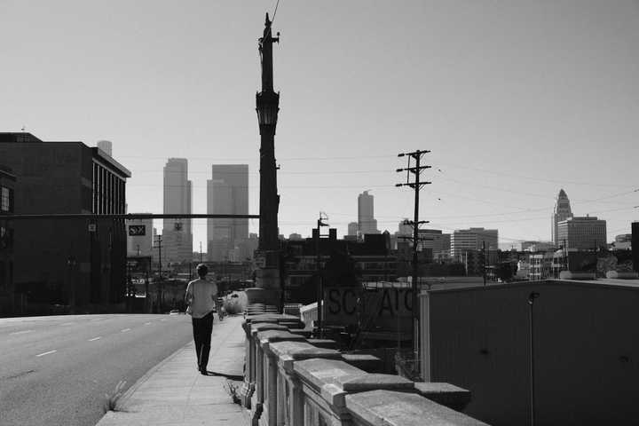 Black and white photo of person walking on a street in a big city