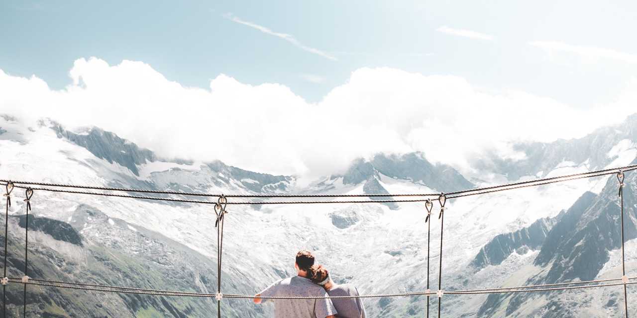 Et par sidder på en bro.
